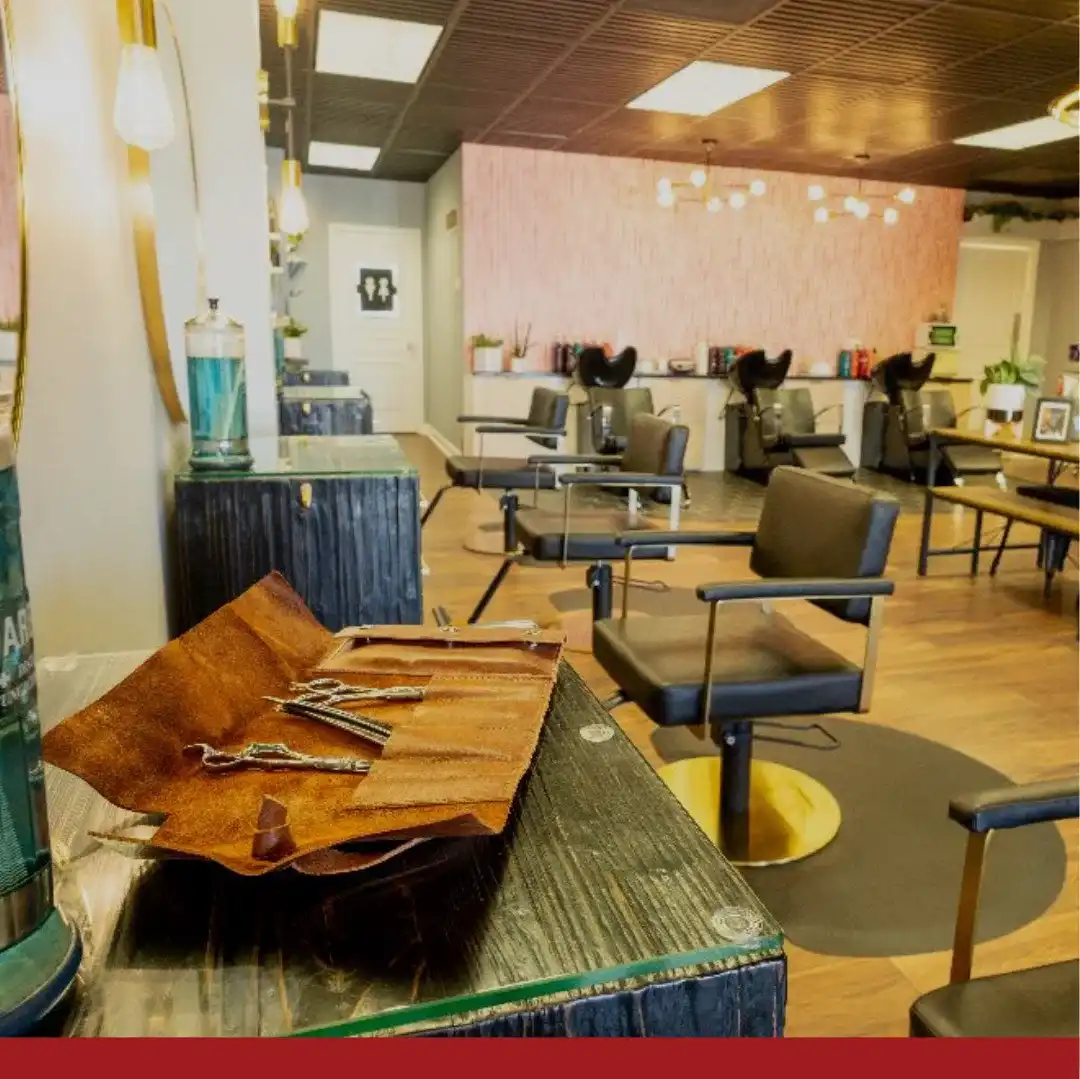 Modern salon interior with stylish chairs, wooden accents, and neatly arranged grooming tools.