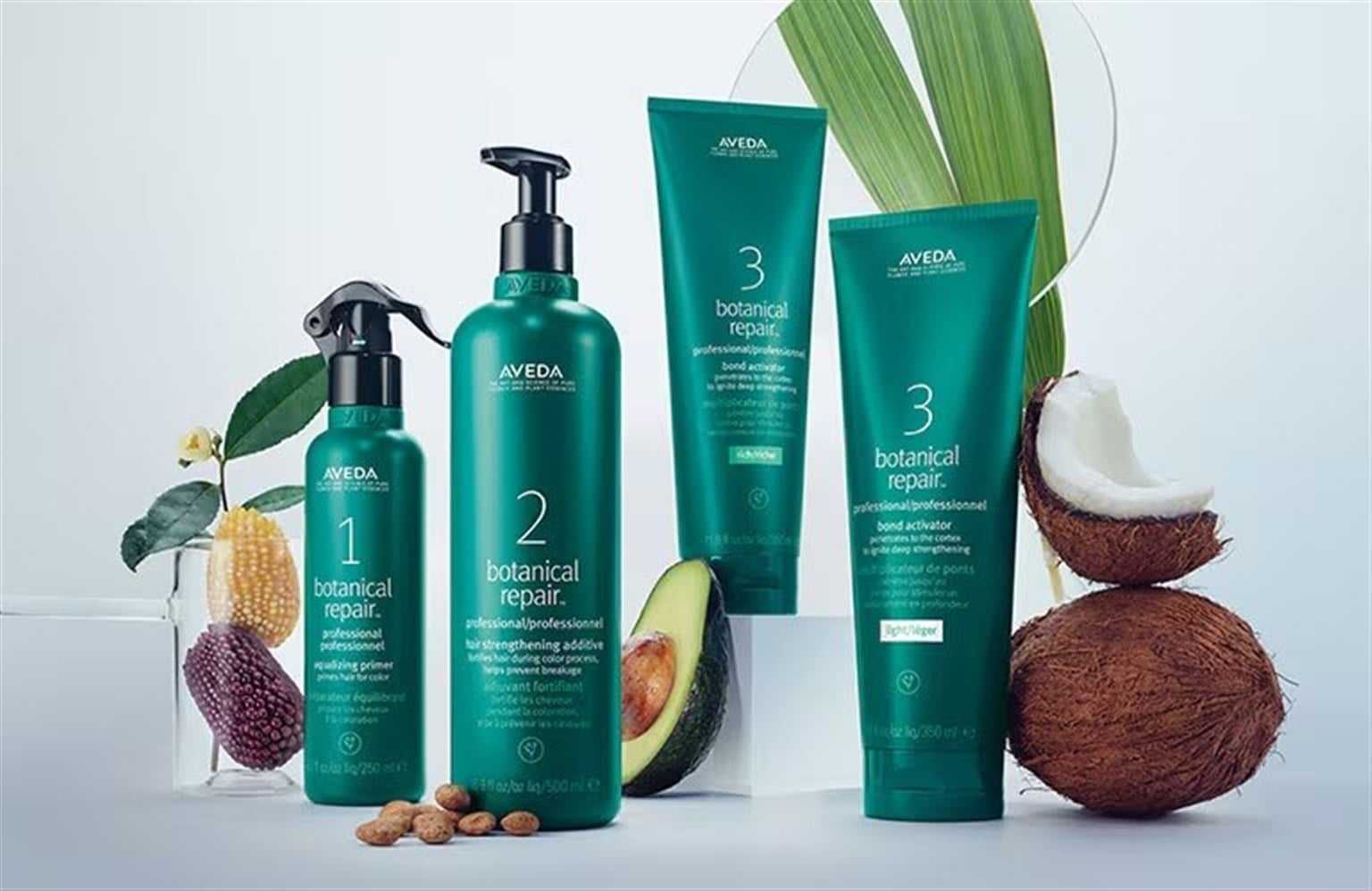 Aveda Botanical Repair hair products displayed with coconut, avocado, corn, and almond elements.